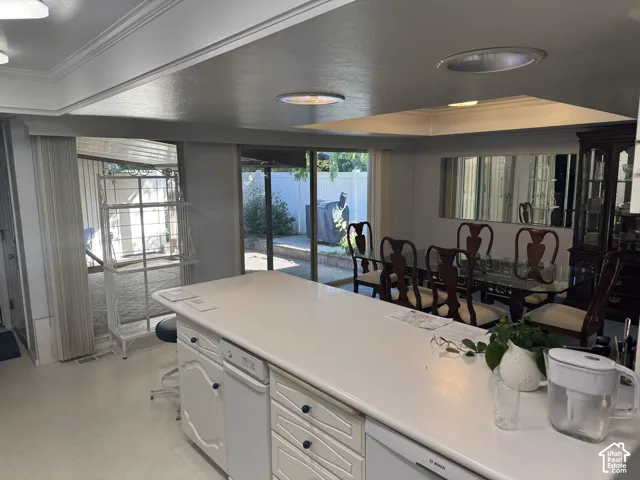 Kitchen island with integrated dishwasher, overhead lighting, and backyard access via sliding glass doors