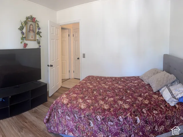 Wood-finish flooring with white walls and a paneled interior door