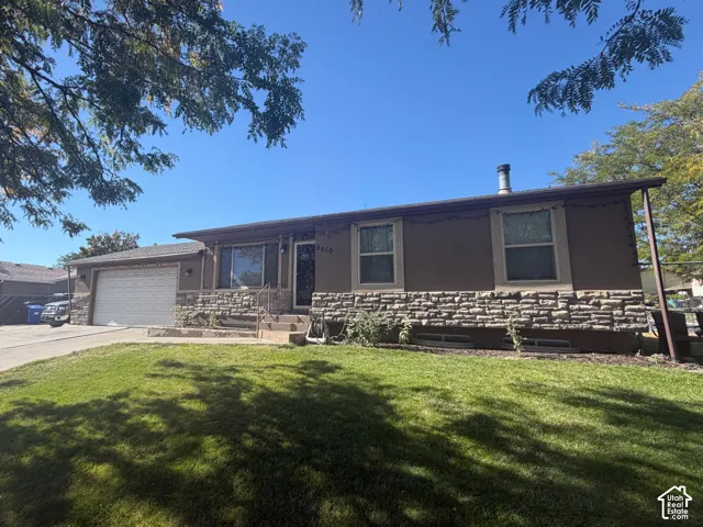 Single-story exterior with a two-car garage, stone veneer siding, and a paved driveway