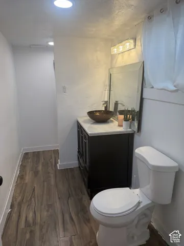 Dark wood-finish flooring, white walls, and recessed lighting