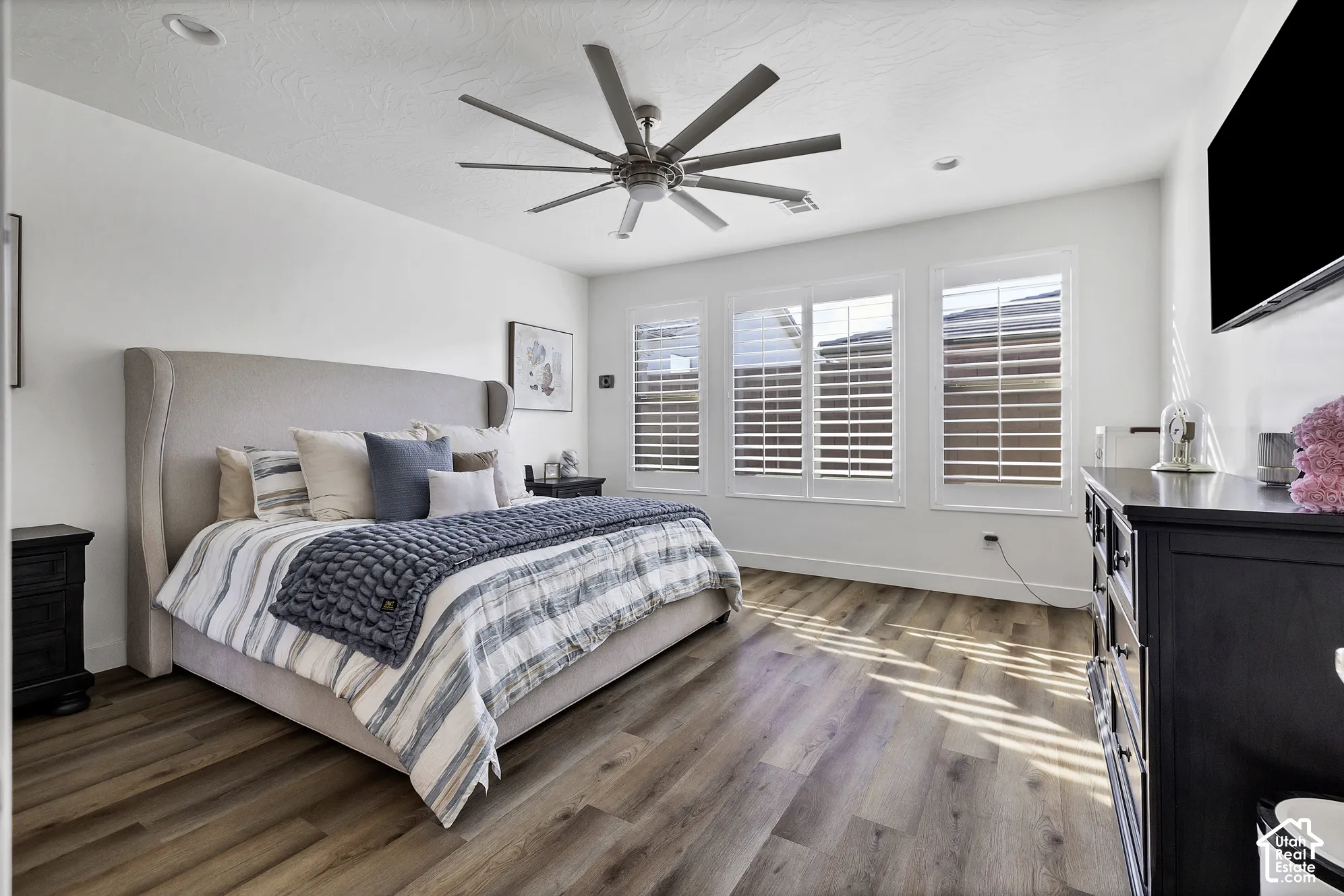 Recessed lighting, wood-finish flooring, and white window shutters