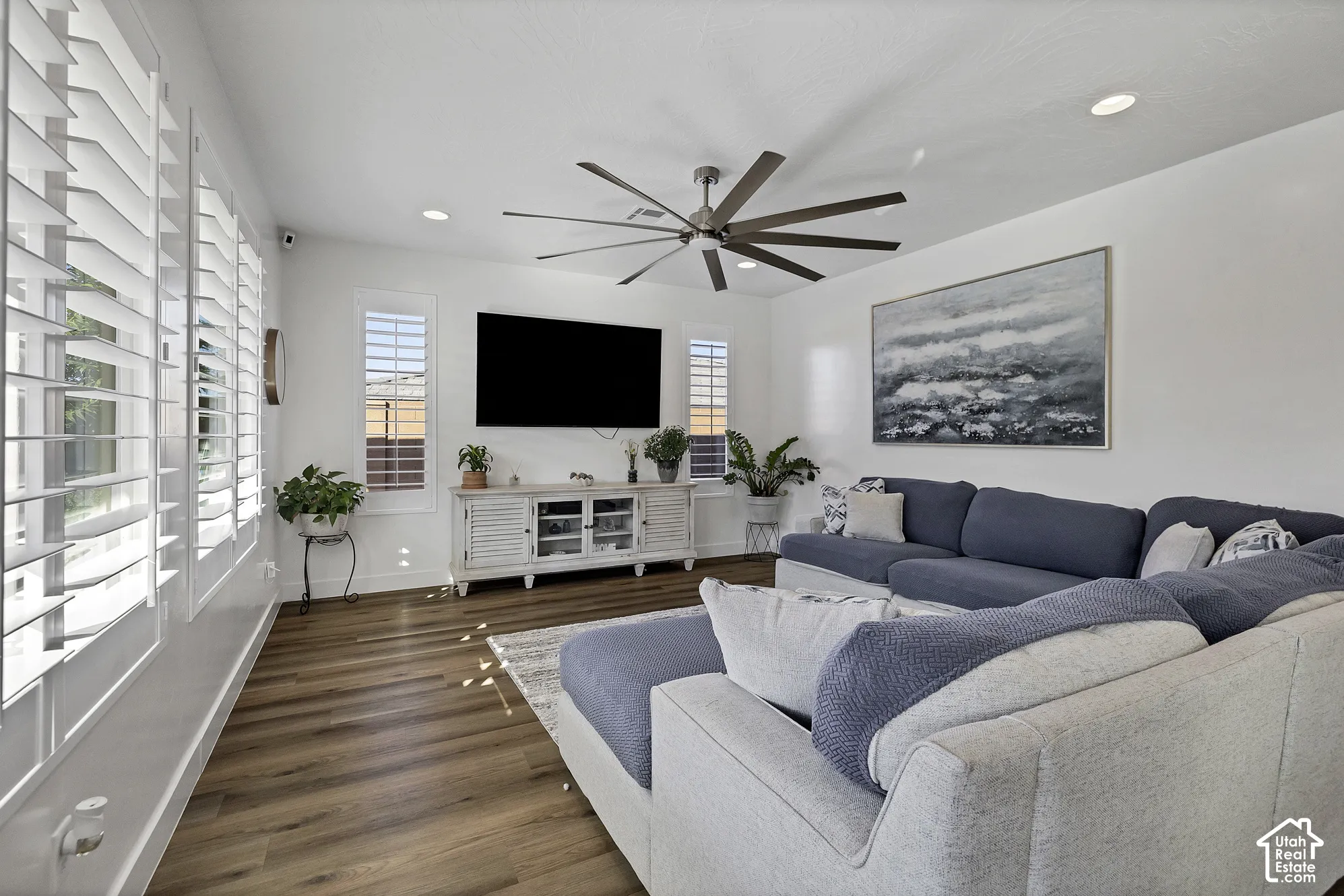Recessed lighting, wood-finish flooring, white plantation shutters, and a ceiling fan with multiple blades