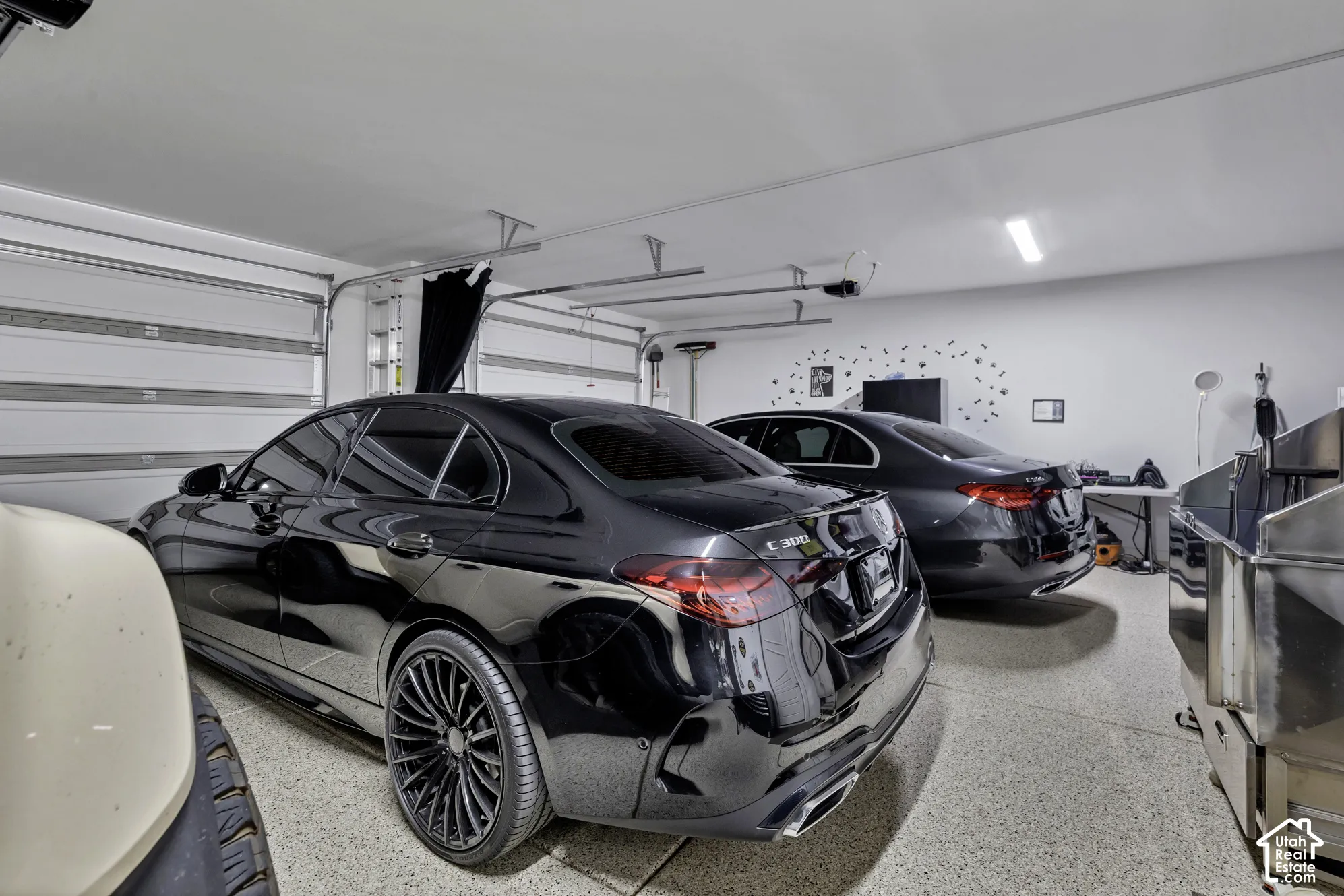 Spacious garage featuring a durable epoxy floor, white painted walls, and overhead fluorescent lighting