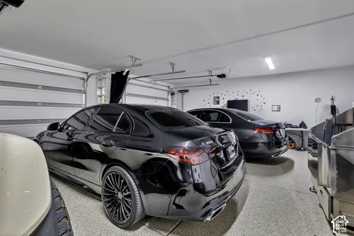Spacious garage featuring a durable epoxy floor, white painted walls, and overhead fluorescent lighting