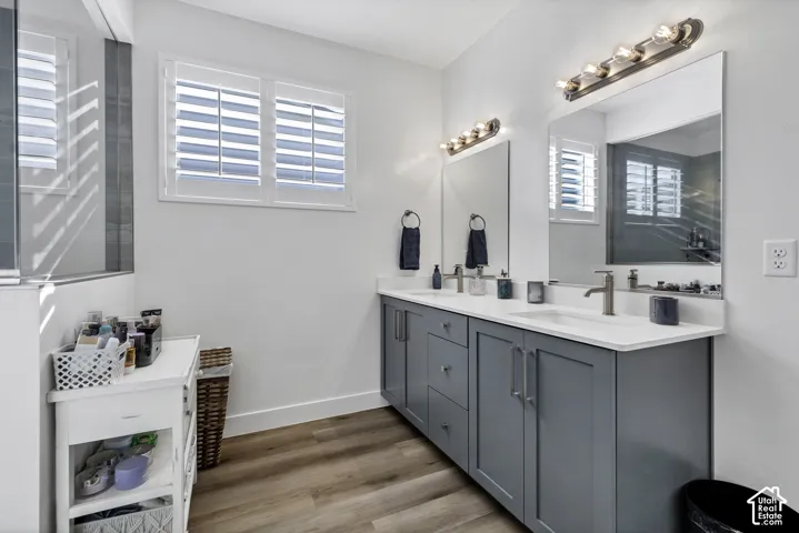 Dual vanity with gray cabinetry, white countertops, and brushed nickel fixtures