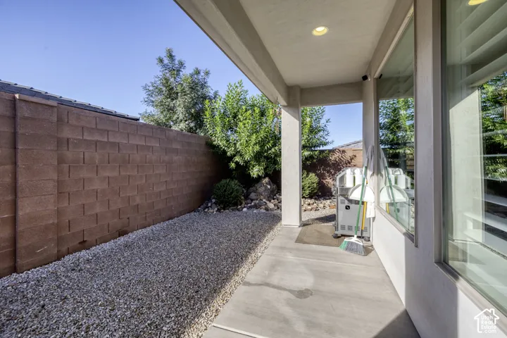 Covered patio with recessed lighting, stucco columns, and an adjacent gravel landscaping bed