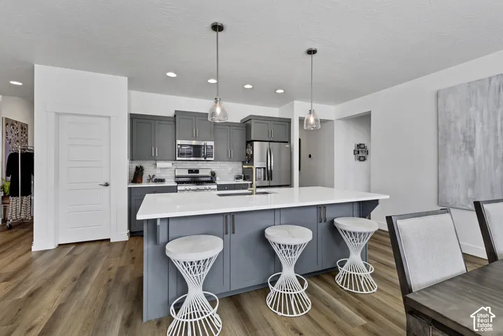 Kitchen featuring wood-finish flooring, recessed lighting, and a center island with pendant lighting