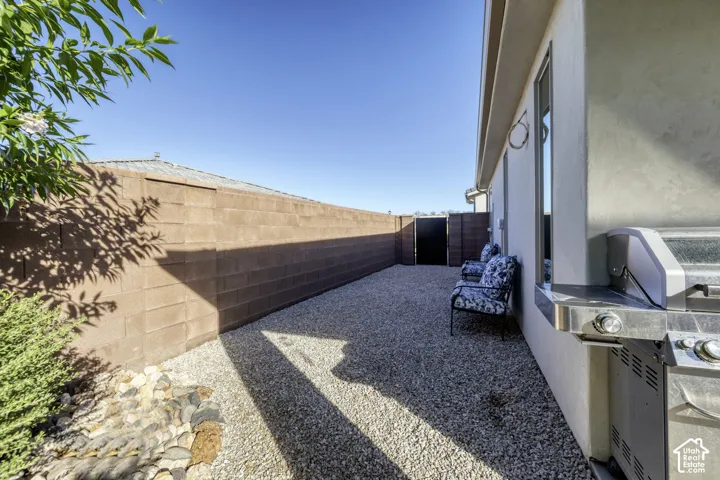 Side yard featuring gravel ground cover, a block wall, and a side gate