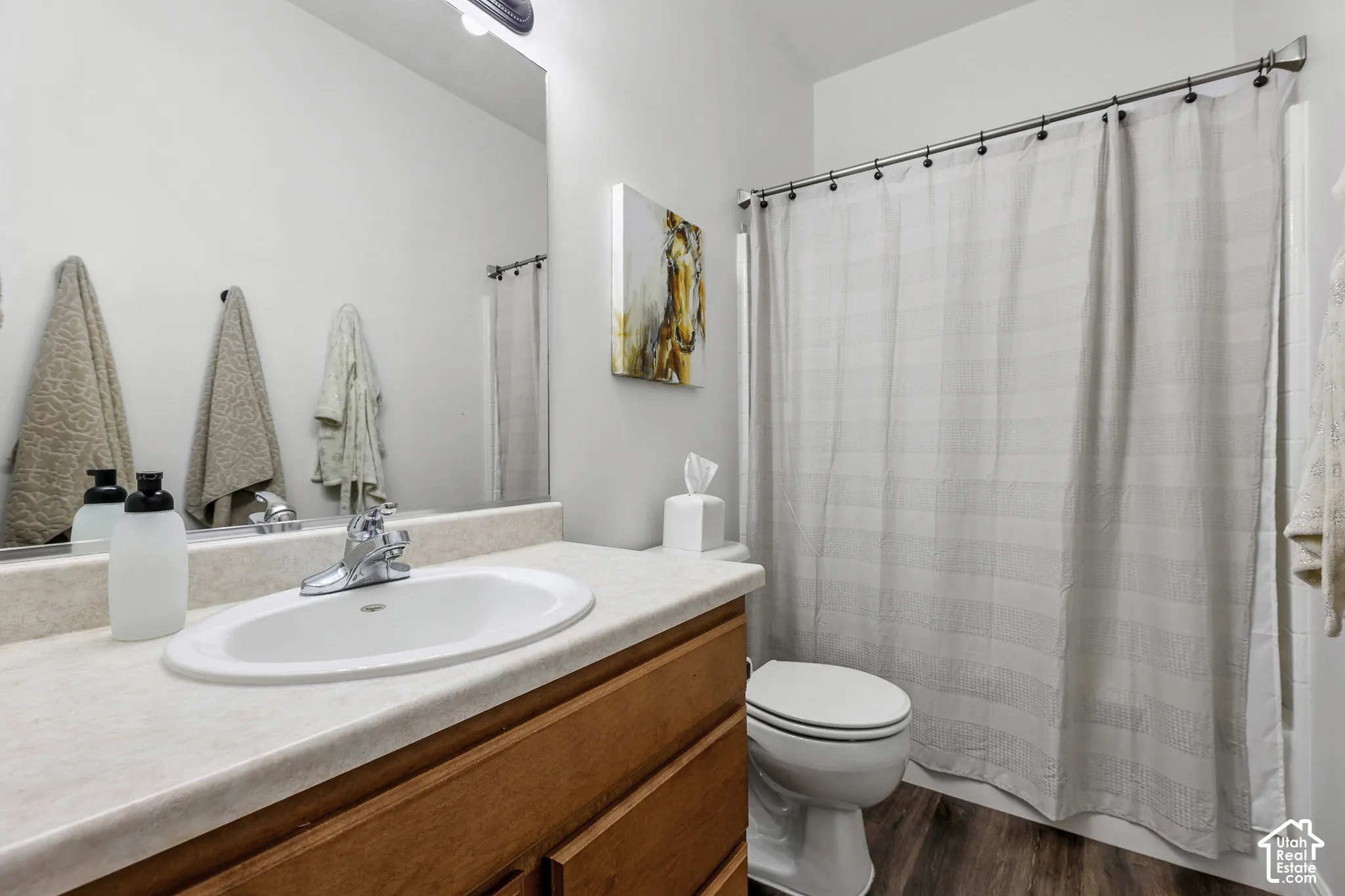 Vanity with integrated sink, chrome faucet, and wood-finish cabinetry
