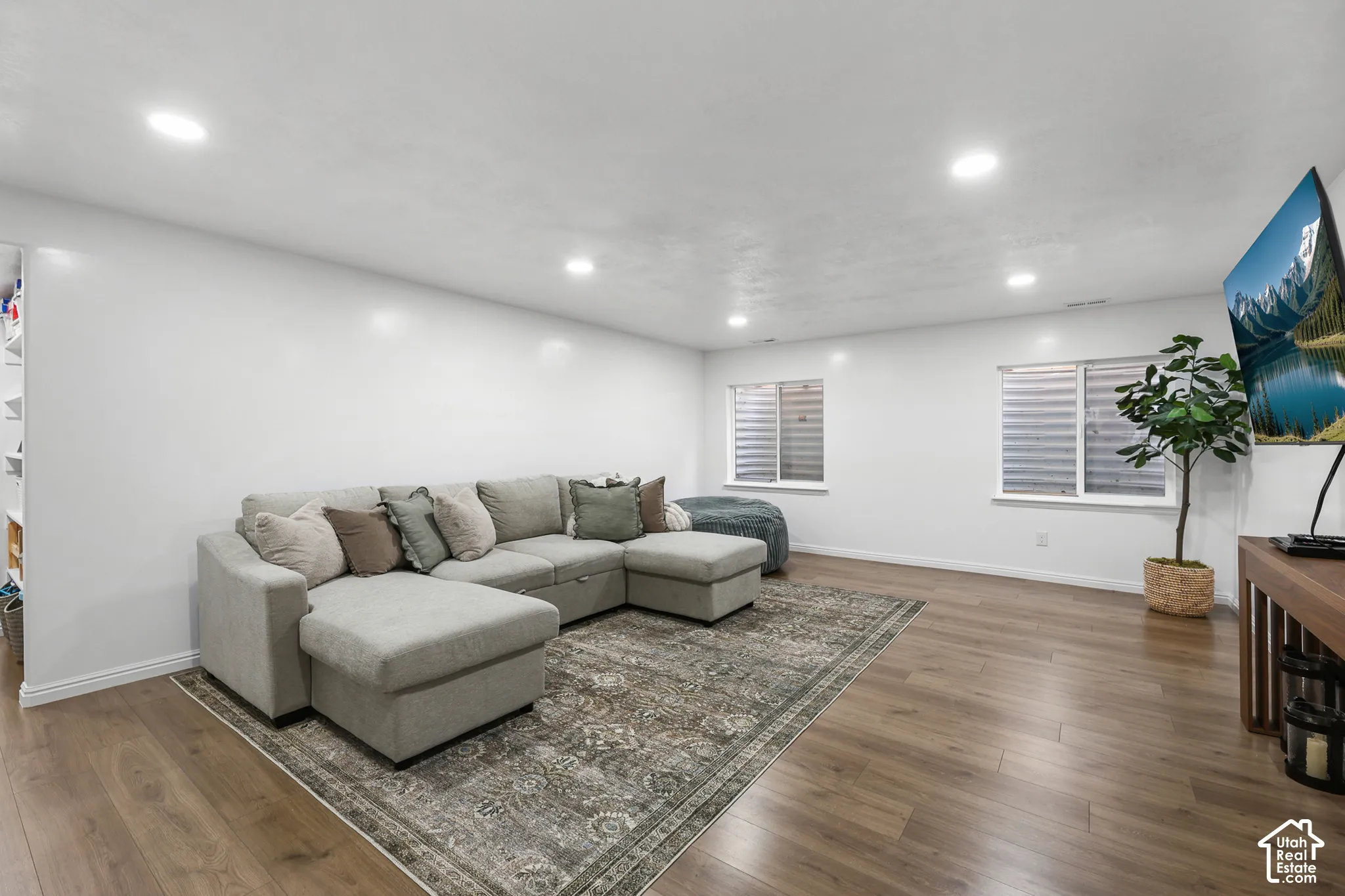 Recessed lighting illuminates wood-finish flooring
