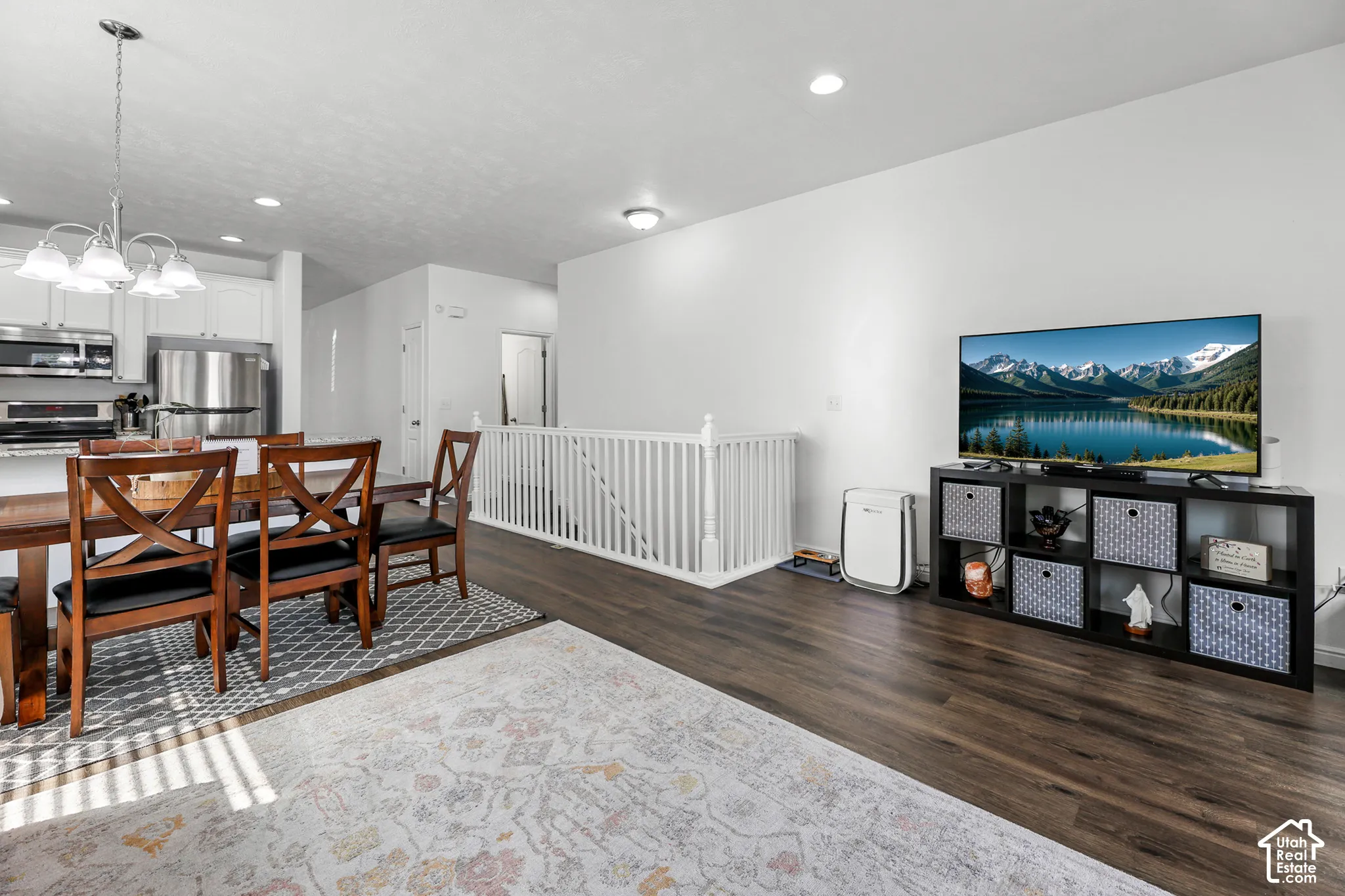 Open-concept living space featuring wood-finish flooring, recessed lighting, and white walls