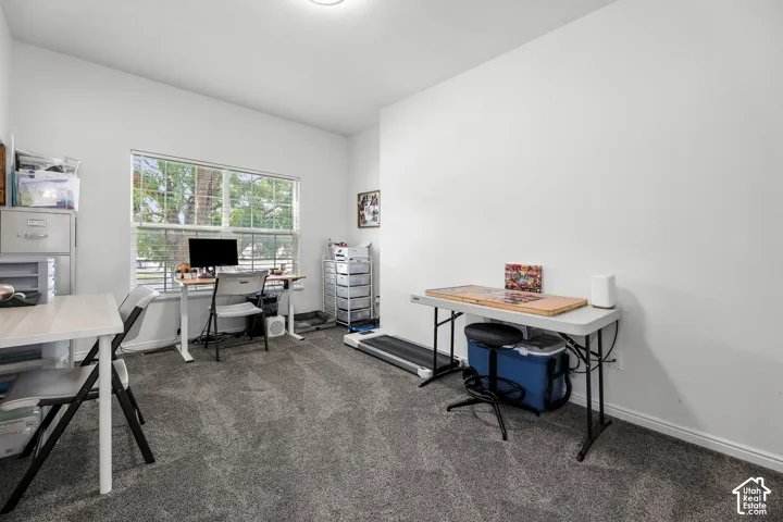 Natural light from a large window, neutral painted walls, and textured carpeting