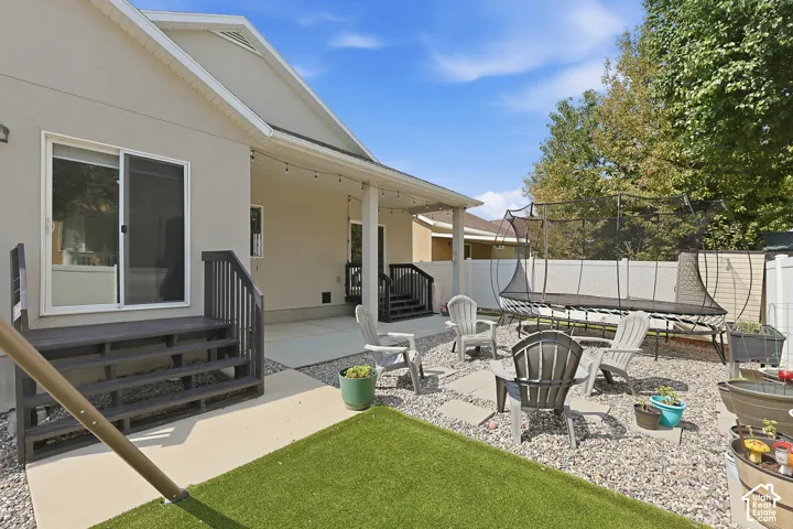 Expansive backyard oasis featuring a manicured lawn, mature landscaping, and white vinyl fencing