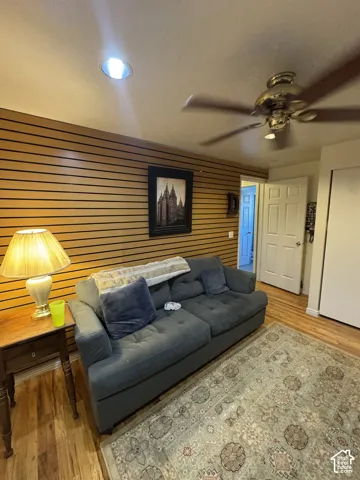Wood-finish flooring, recessed ceiling lighting, and a ceiling fan with integrated lighting