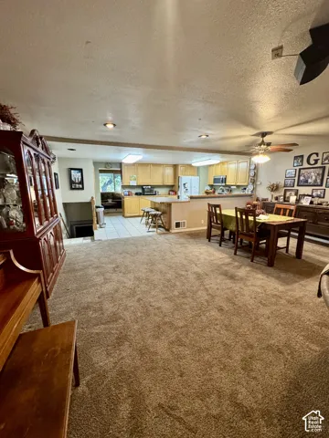 Open-concept living space featuring carpet flooring, recessed lighting, and a dining area with a ceiling fan