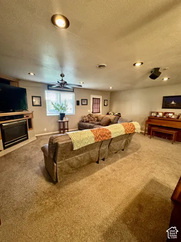 Recessed ceiling lighting, ceiling fan, carpet flooring, fireplace, and window with blinds