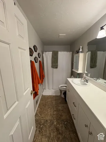 White paneled door, tiled flooring, built-in vanity with integrated sink, and a wall-mounted mirror