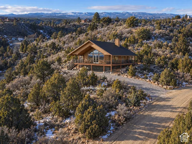 Wood-sided cabin-style residence with a dark shingled roof, elevated deck, and prominent A-frame windows