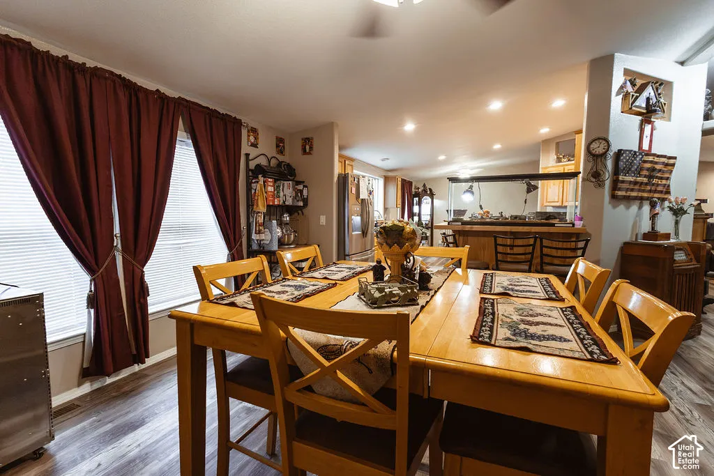 Wood-finish flooring, recessed lighting, and large windows with blinds