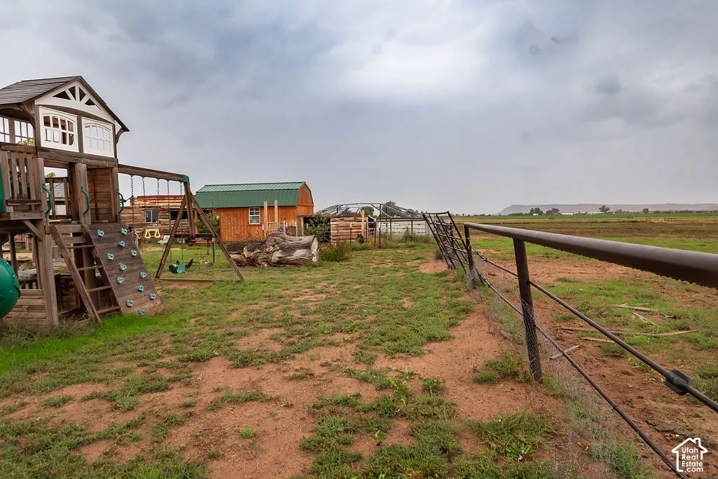 Expansive outdoor space featuring a playset with a rock wall, swing set, and slide