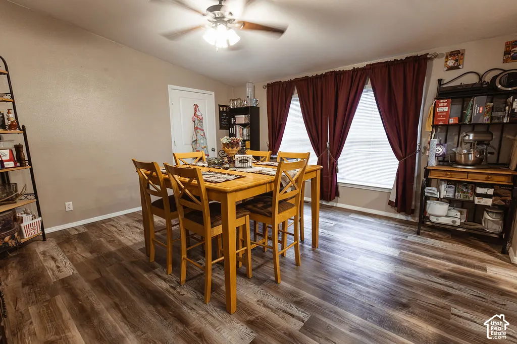 Wood-finish flooring, two windows, and a ceiling fan with integrated lighting