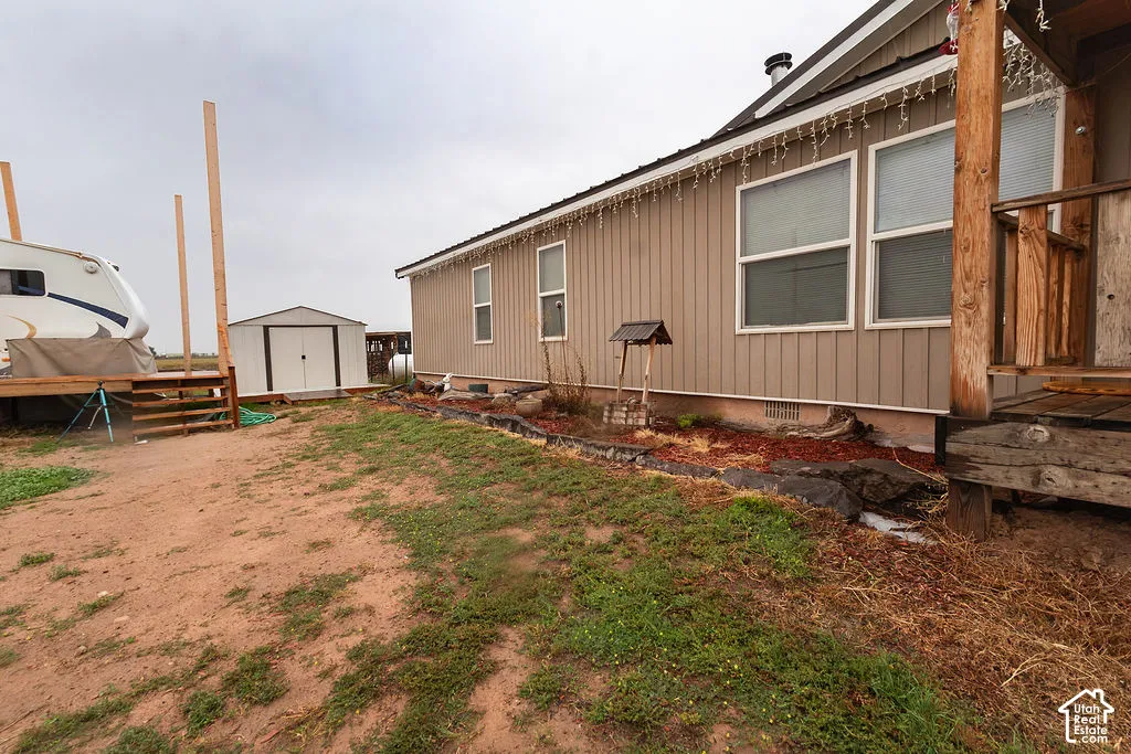 Siding exterior with multiple windows, accompanied by an outdoor storage shed