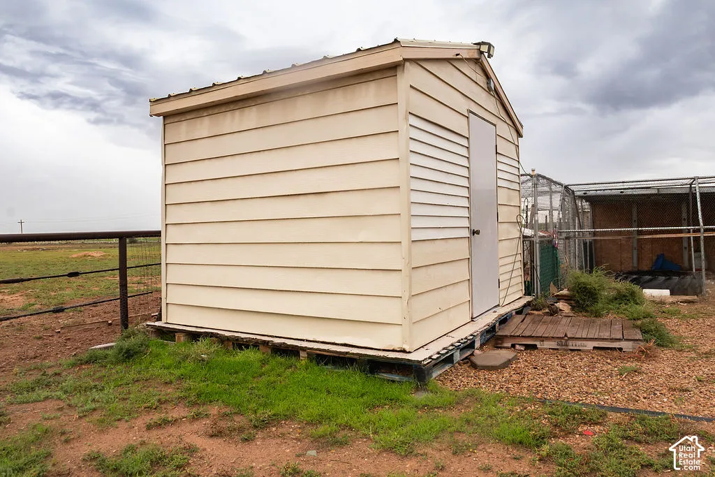 Detached storage shed with horizontal siding, a gabled roof, and a single entry door