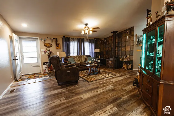 Spacious living area featuring wood-finish flooring, a ceiling fan with light fixture, and recessed lighting