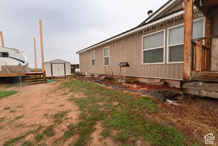 Siding exterior with multiple windows, accompanied by an outdoor storage shed