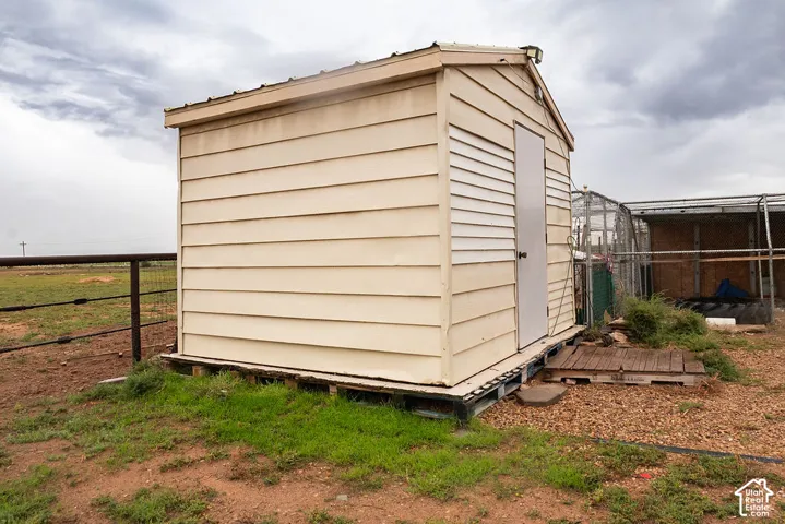 Detached storage shed with horizontal siding, a gabled roof, and a single entry door