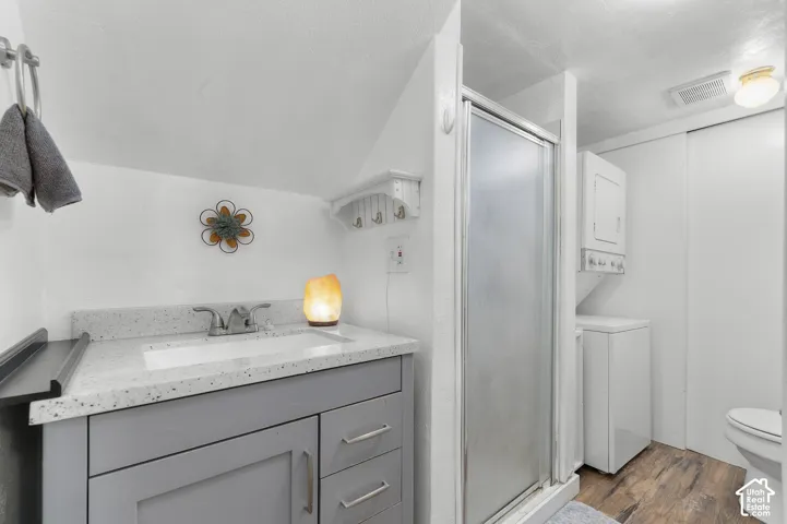 Bathroom with a single vanity, undermount sink, and light-toned countertop. stackable washer and dryer