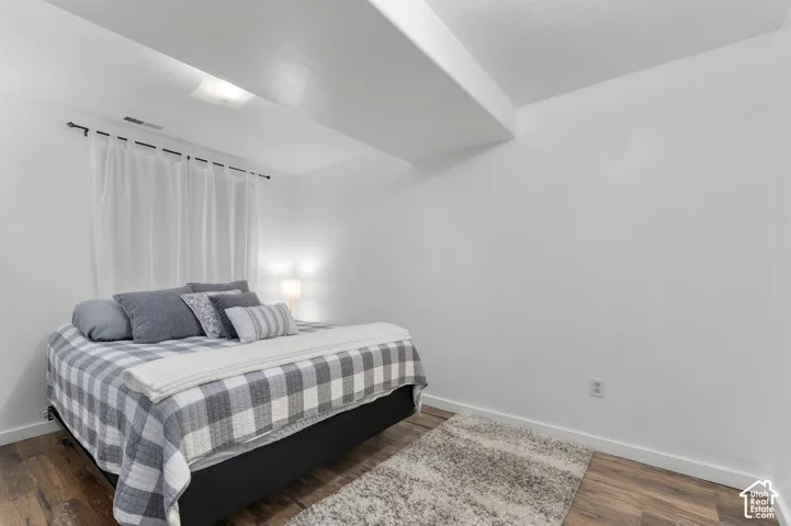 Wood-finish flooring with white baseboards and a full wall window