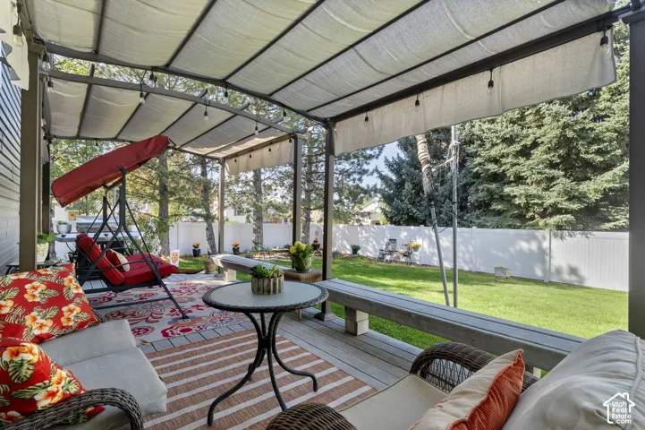 Spacious Trex deck with two pergola coverings and backyard new white vinyl privacy fence