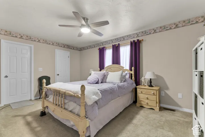 Master room featuring a ceiling fan with integrated lighting, two paneled doors, and a window