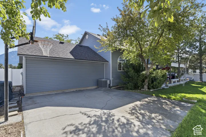 Concrete basketball pad with brand new vinyl siding and a newly shingled roof