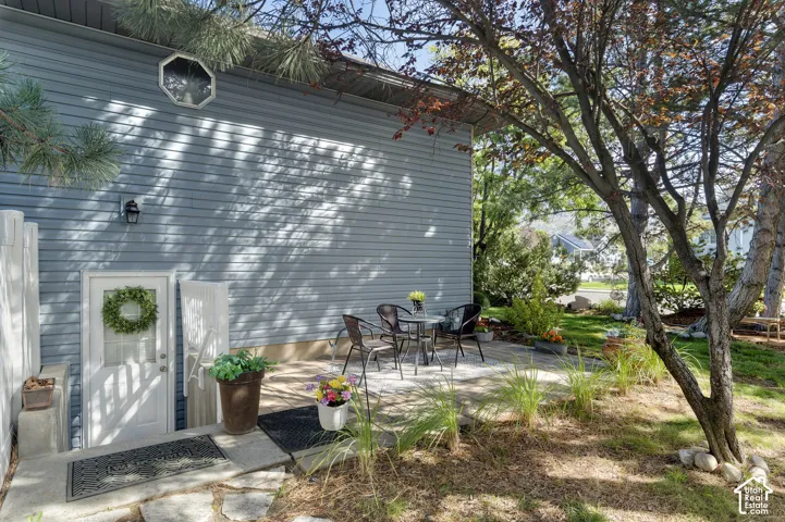 Brand new siding exterior with a white door, an exterior wall light fixture, and an octagonal window, entrance to access daylight basement level and basement apartment