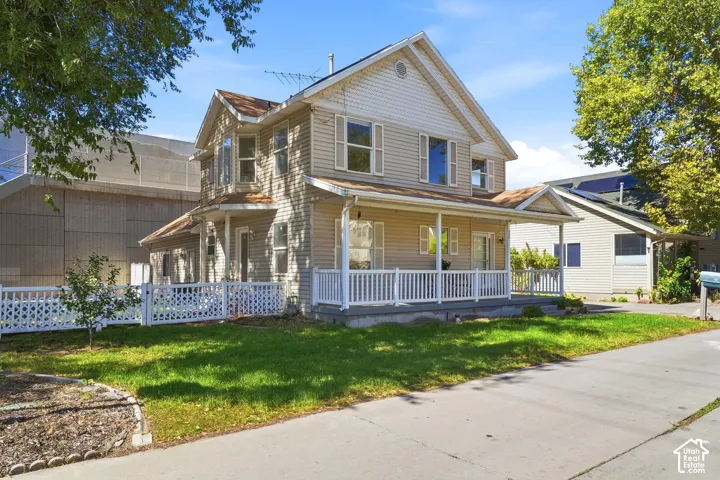 Two-story residence with a covered front porch featuring white railing
