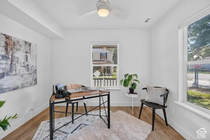 Recessed lighting, wood-finish flooring, white walls, and a ceiling fan with integrated lighting