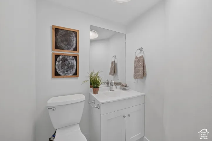 White vanity with integrated sink, chrome faucet, and mirrored wall