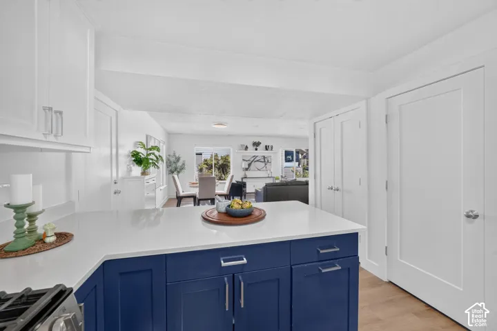Kitchen island with blue cabinetry, white countertops, and stainless hardware