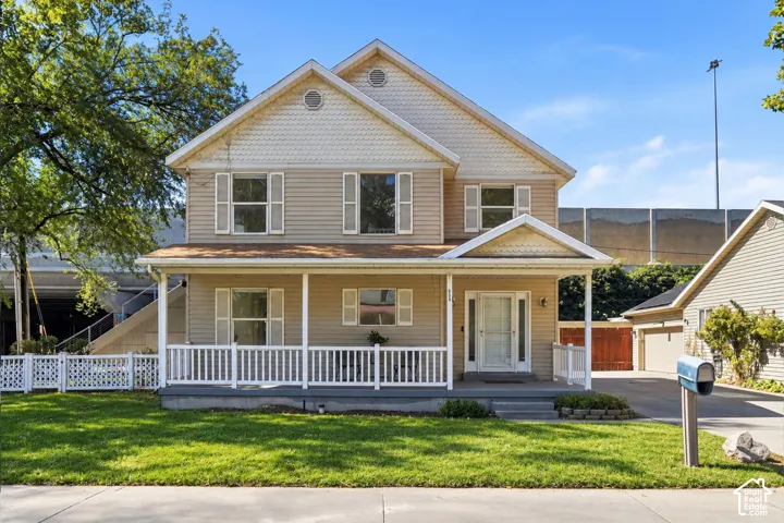 Two-story residence with a covered front porch featuring white railings