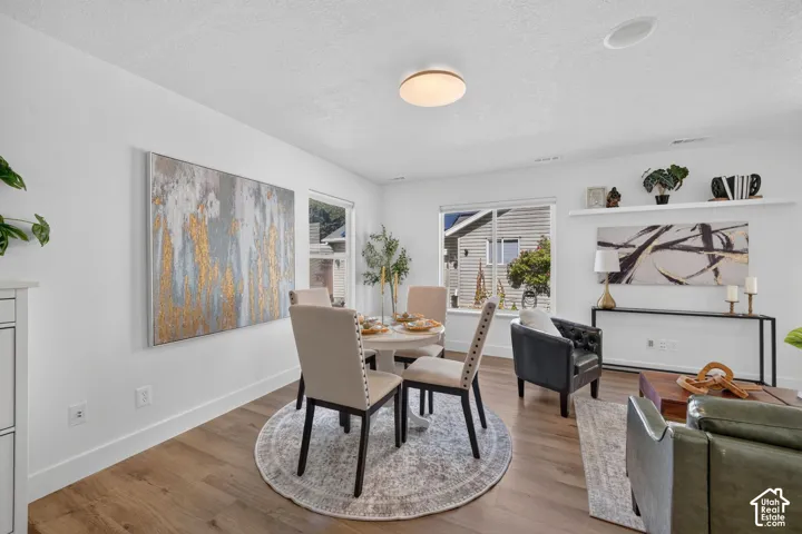 Recessed lighting, wood-finish flooring, white walls, and a window with natural light
