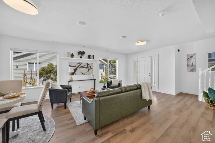 Open-concept living space featuring wood-finish flooring, recessed lighting, and large windows