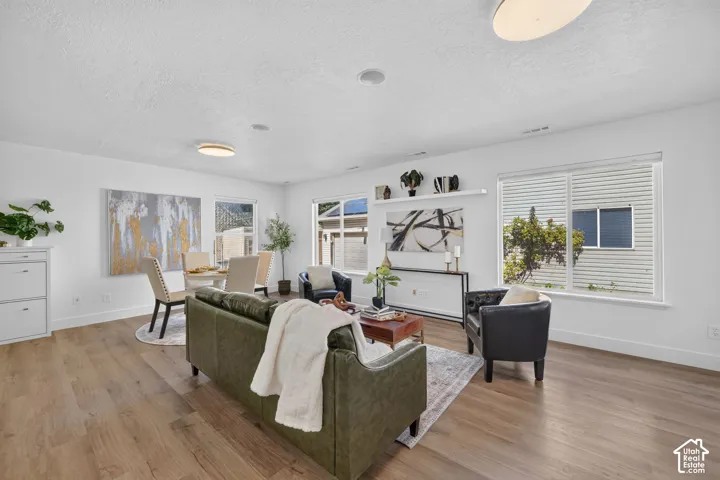Open concept living area featuring wood-finish flooring, recessed lighting, and large windows