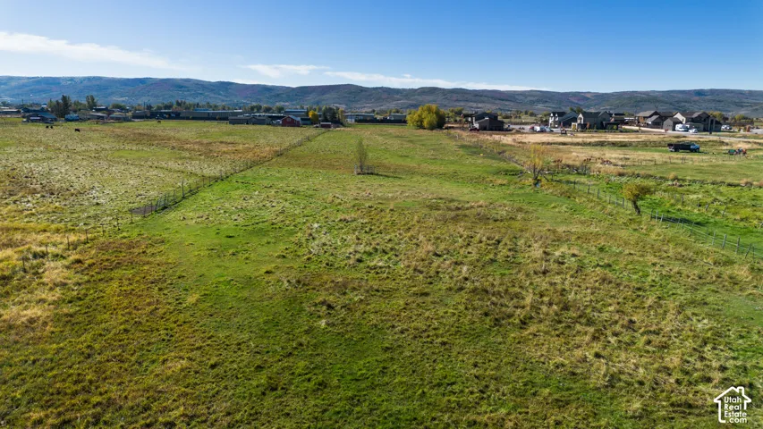 Expansive green land area featuring natural terrain and distant mountains
