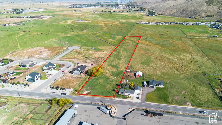 Expansive lot featuring a primary residence, a red barn, and lush green acreage