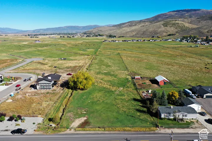 Expansive agricultural land with mountainous backdrop and scattered residential development