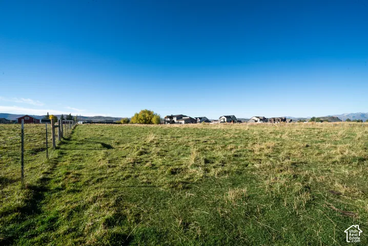 Expansive green field with a wooden post and wire fence
