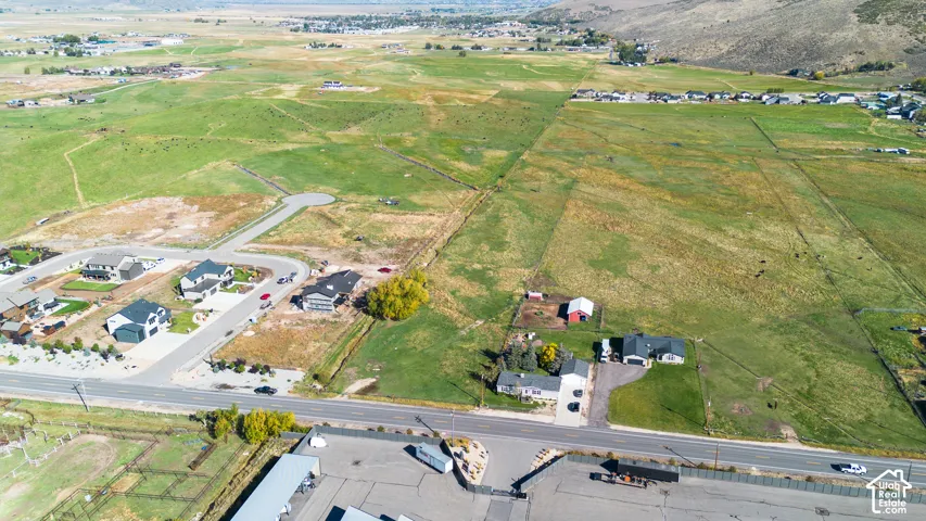 Extensive acreage featuring open fields, paved road frontage, and established residential areas