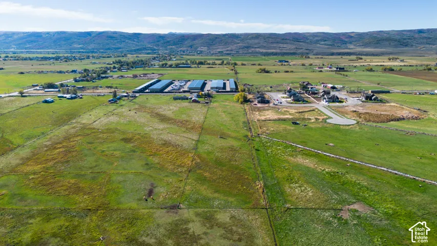 Expansive green fields with distant mountainous terrain